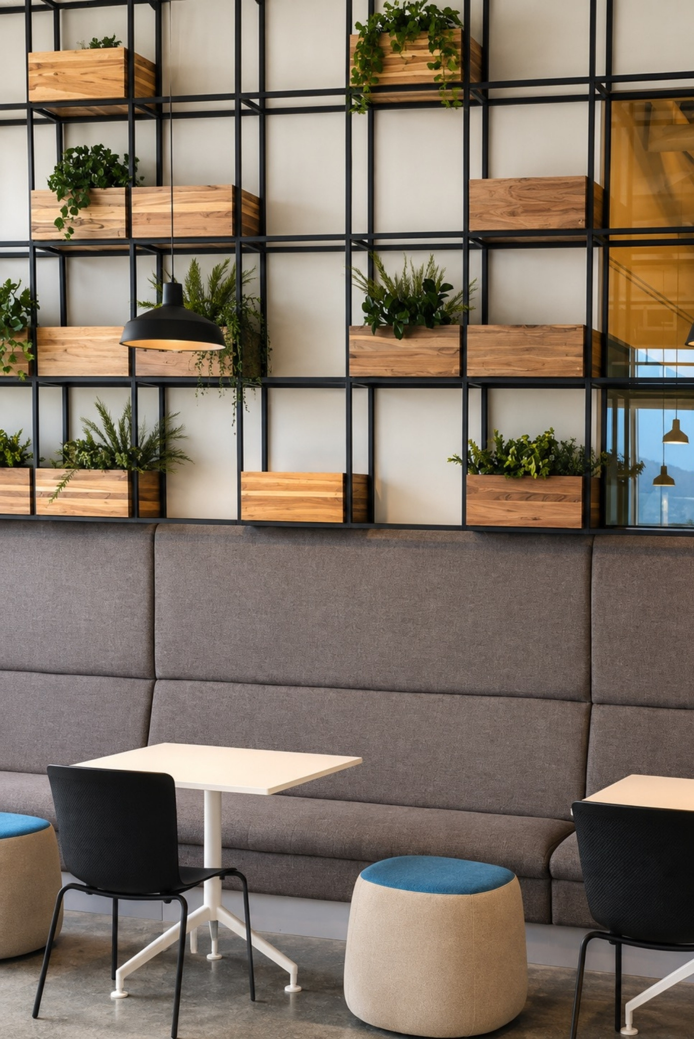 Estructura metálica de pared con cajones de madera y helechos sobre una banca corrida