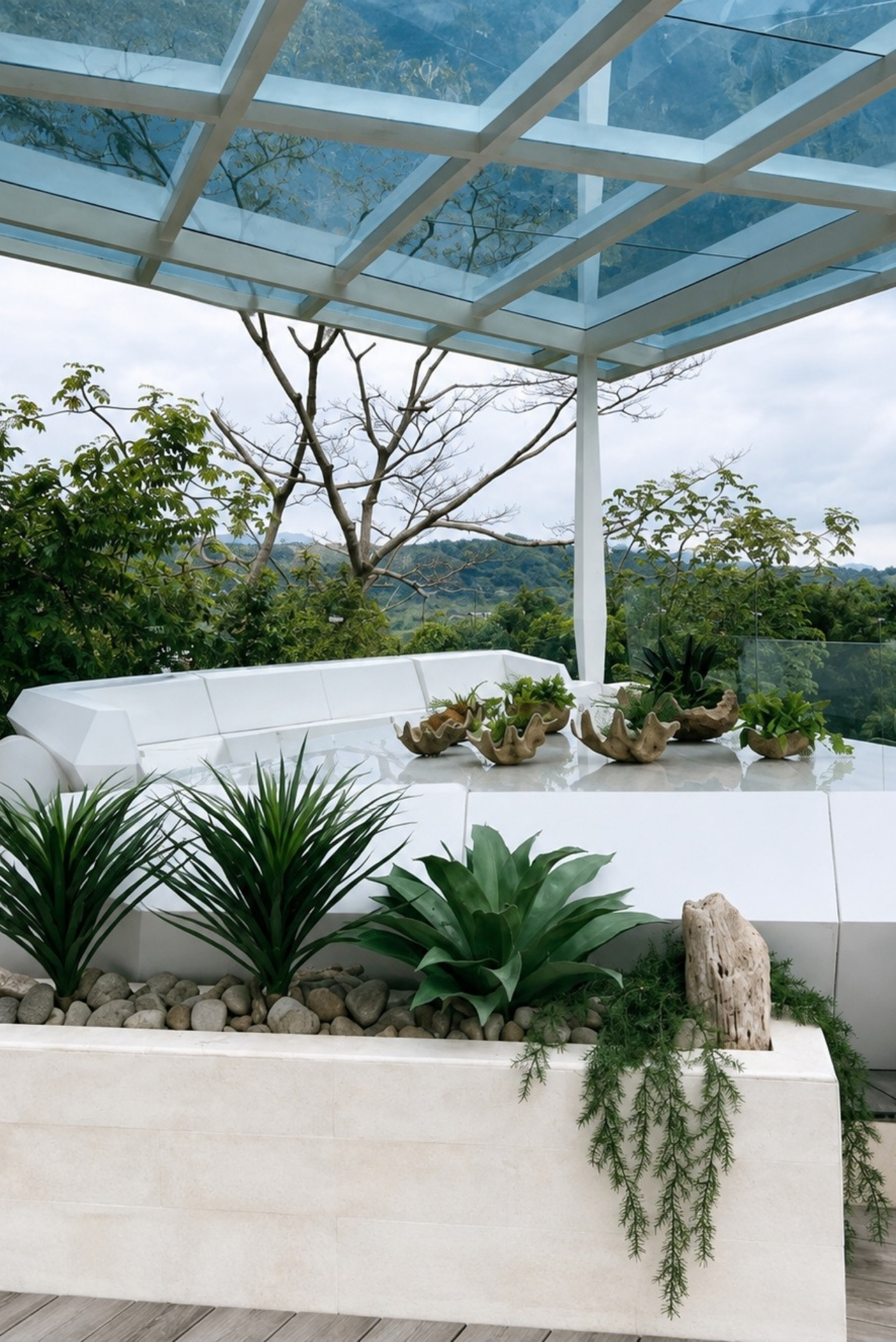 Jardinera blanca con agaves, piedras y plantas colgantes bajo una pérgola de vidrio en una terraza